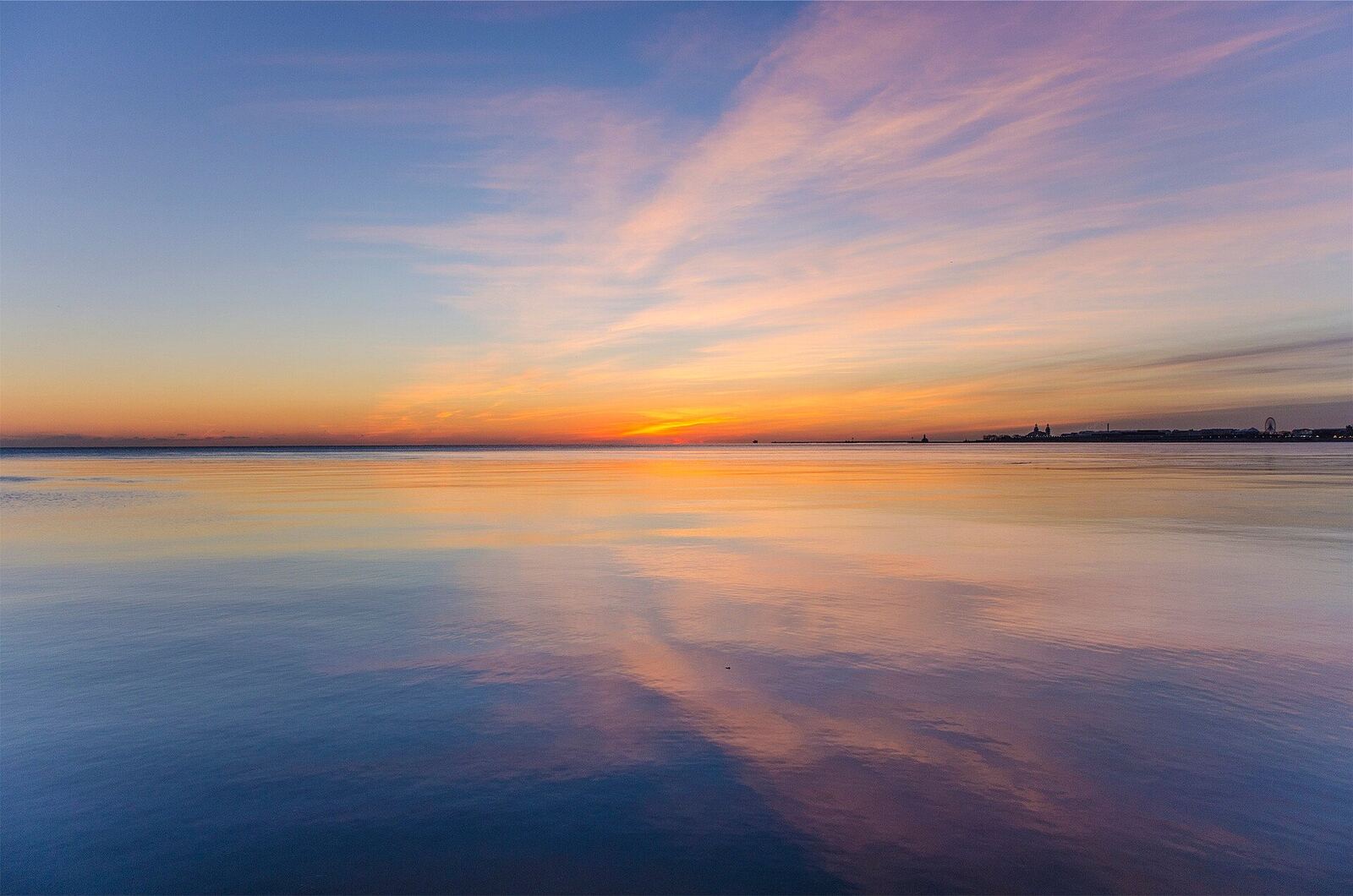 A vibrant sunset reflects on calm water, evoking feelings of peace and hope for healing after betrayal.