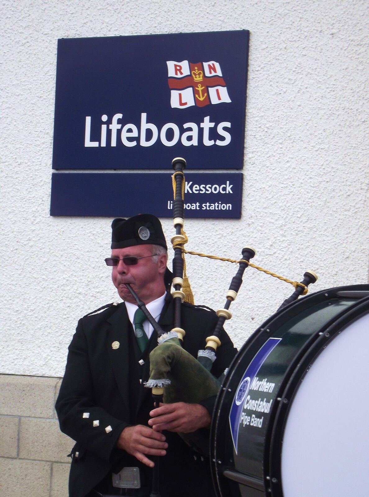 Kessock Bagpipes | Love Hurtz A bagpiper performs outdoors near the Kessock lifeboat station, illustrating community and resilience.