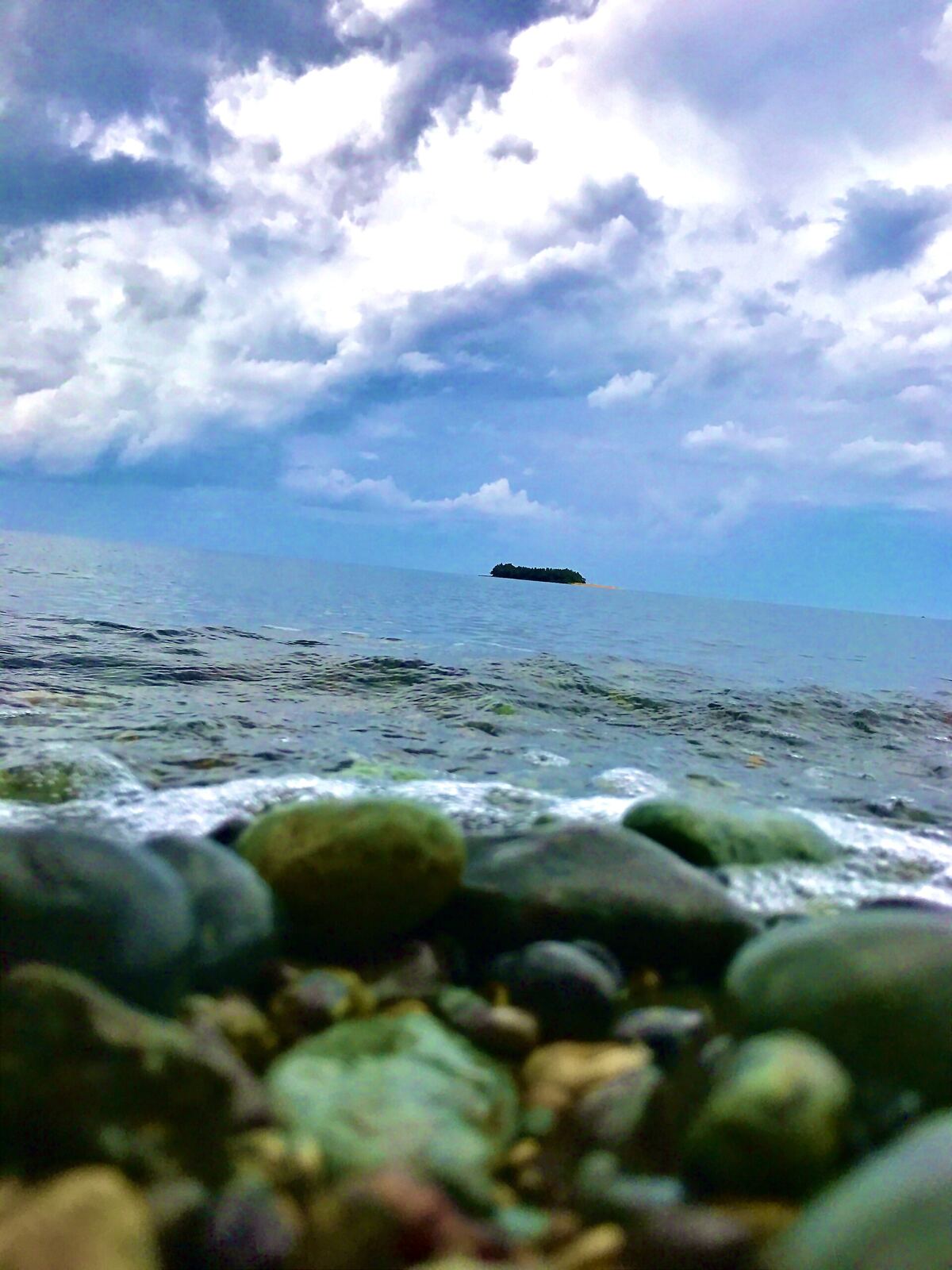 A rocky beach meets the ocean under a cloudy sky, representing emotional release and healing after betrayal.