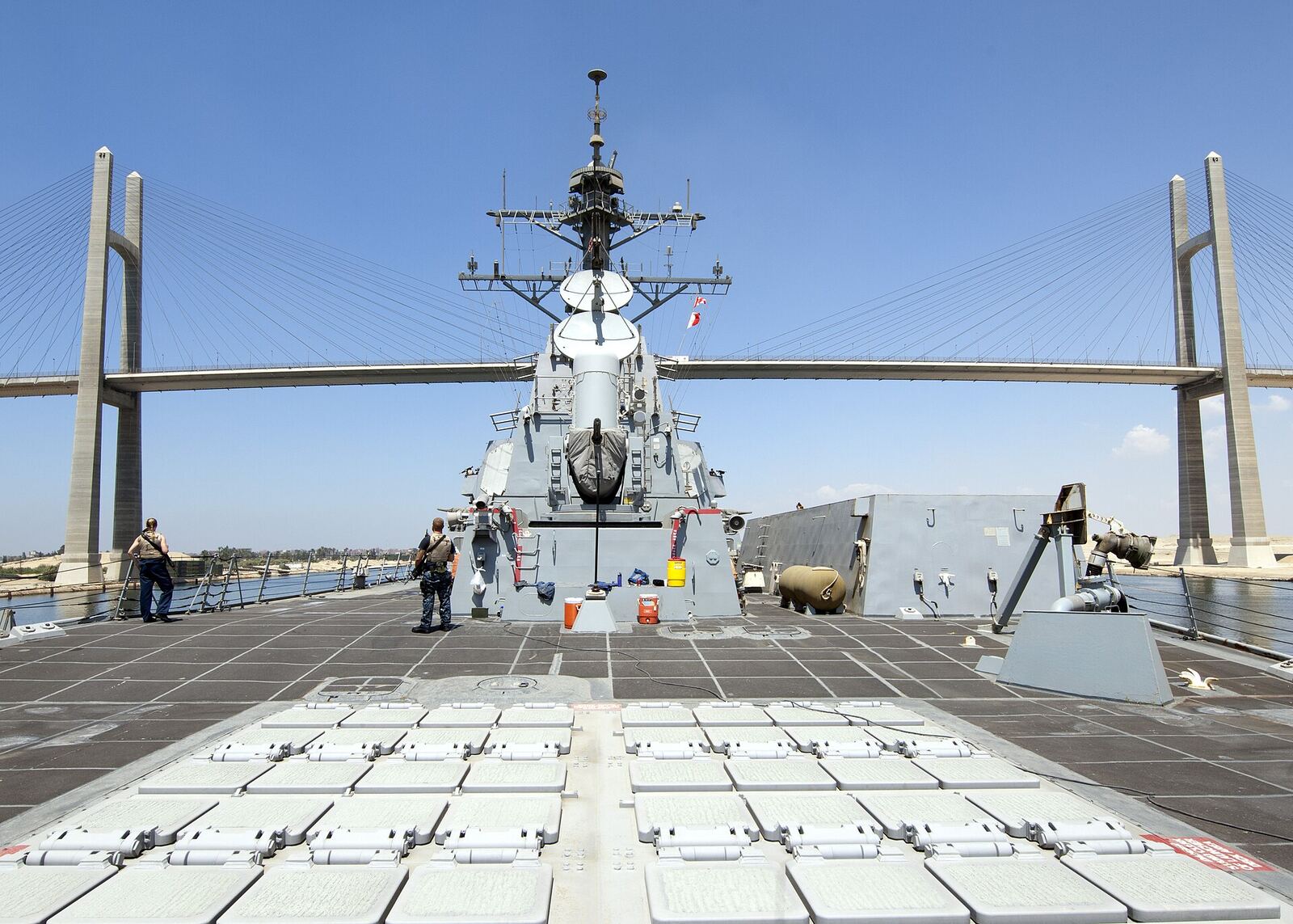 US Navy Ship | Love Hurtz A US Navy destroyer ship is docked with a bridge in the background, illustrating themes of resilience and overcoming.
